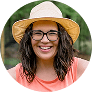 team-cassie Smiling brunette woman in a gardening hat and glasses