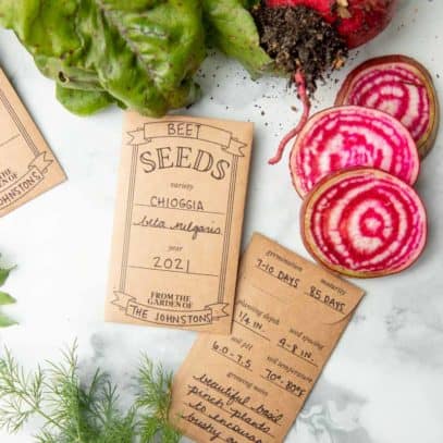 Two seed packets with handwritten labels, next to sliced beets.