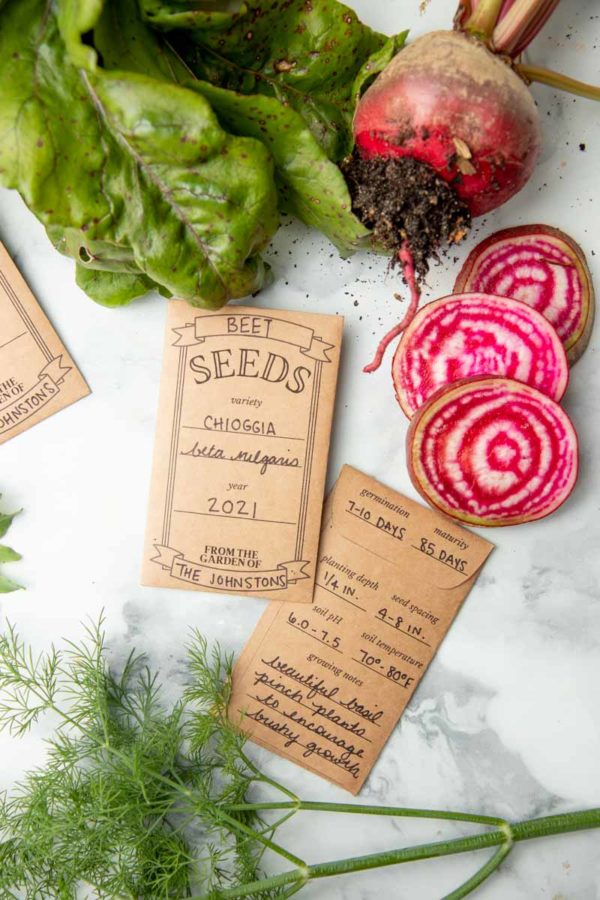 Two seed packets with handwritten labels, next to sliced beets.